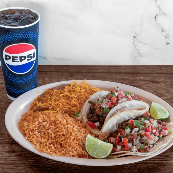 Adalbertacos Mexican Food plate with two tacos, rice, beans, and a Pepsi drink.