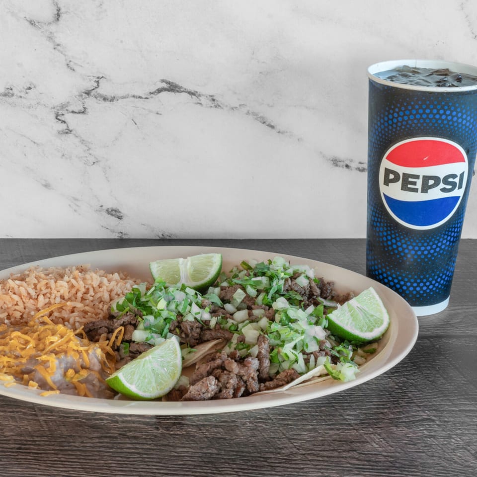 Adalbertacos Mexican Food plate with carne asada tacos, rice, beans, and a Pepsi.